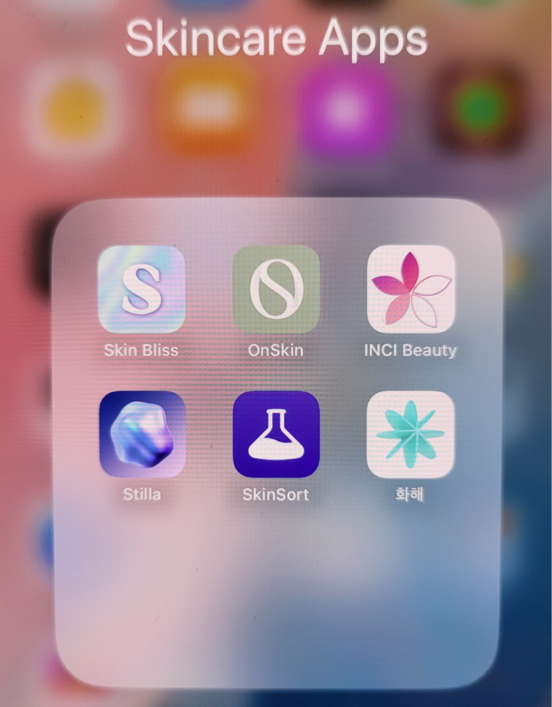 A screenshot of a smartphone folder labeled 'Skincare Apps,' displaying six app icons: Skin Bliss, OnSkin, INCI Beauty, Stilla, SkinSort, and Hwahae. The background is blurred, and the icons are arranged in a grid format.